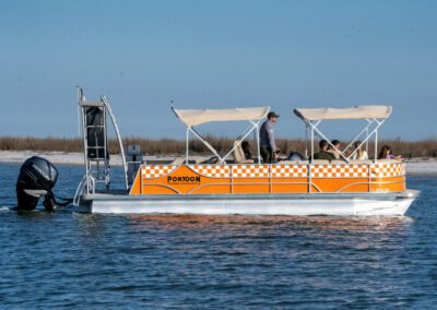 Family enjoying charter pontoon boat with slide and captain.