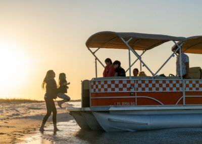 Family enjoying charter pontoon boat with slide and captain.