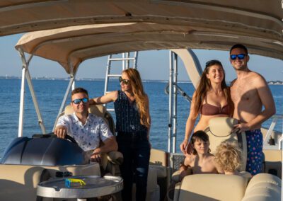 Family enjoying charter pontoon boat with slide and captain.